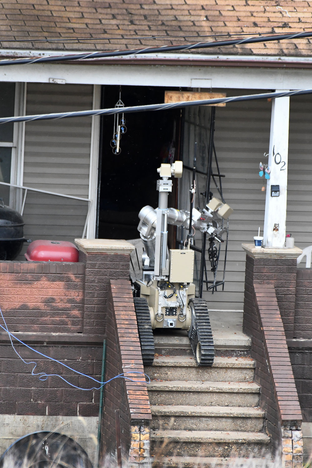 A MSHP ROBOT removes the screen door at 102 Market Street in Hermann on Monday. Drones were also used in an attempt to inspect the home’s interior for signs of the suspect, Kenneth Lee Simpson.